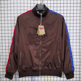 Barca Brown jacket with red and blue accents on a hanger against a grid background